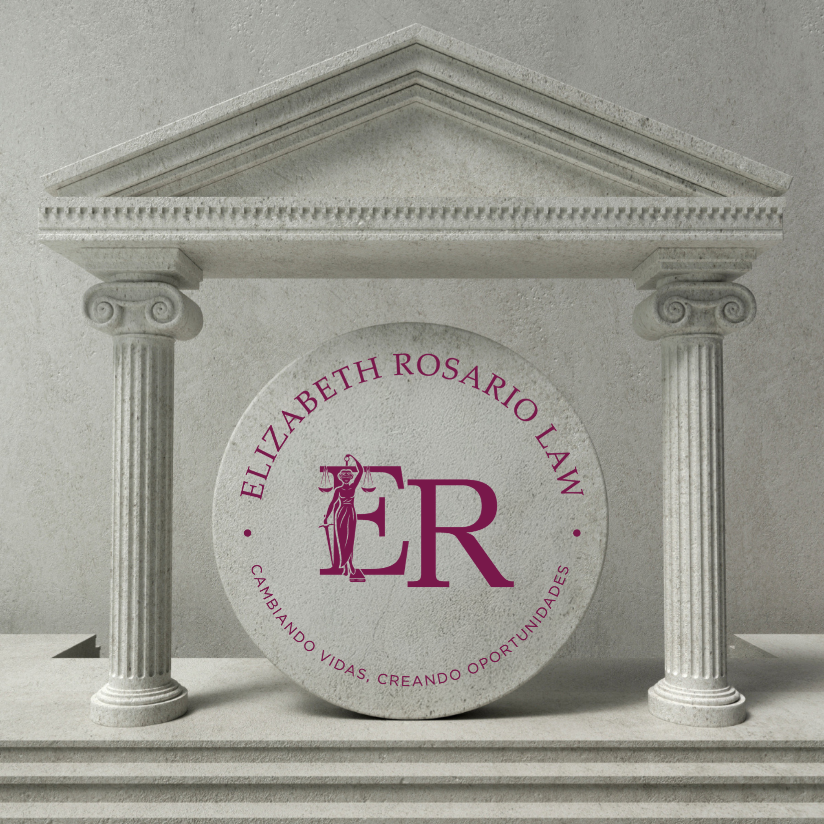 A stone monument with classical architecture, including two columns and a triangular pediment. A circular logo on the monument features the initials ER with a figure of Lady Justice holding scales and a sword, surrounded by the text 'Elizabeth Rosari