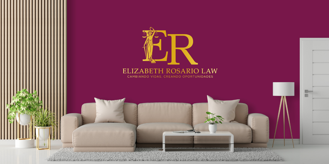 Interior office space with a beige sofa, beige pillows, potted plants, a white coffee table with a plant, and a purple wall with a gold logo and text for Elizabeth Rosario Law.