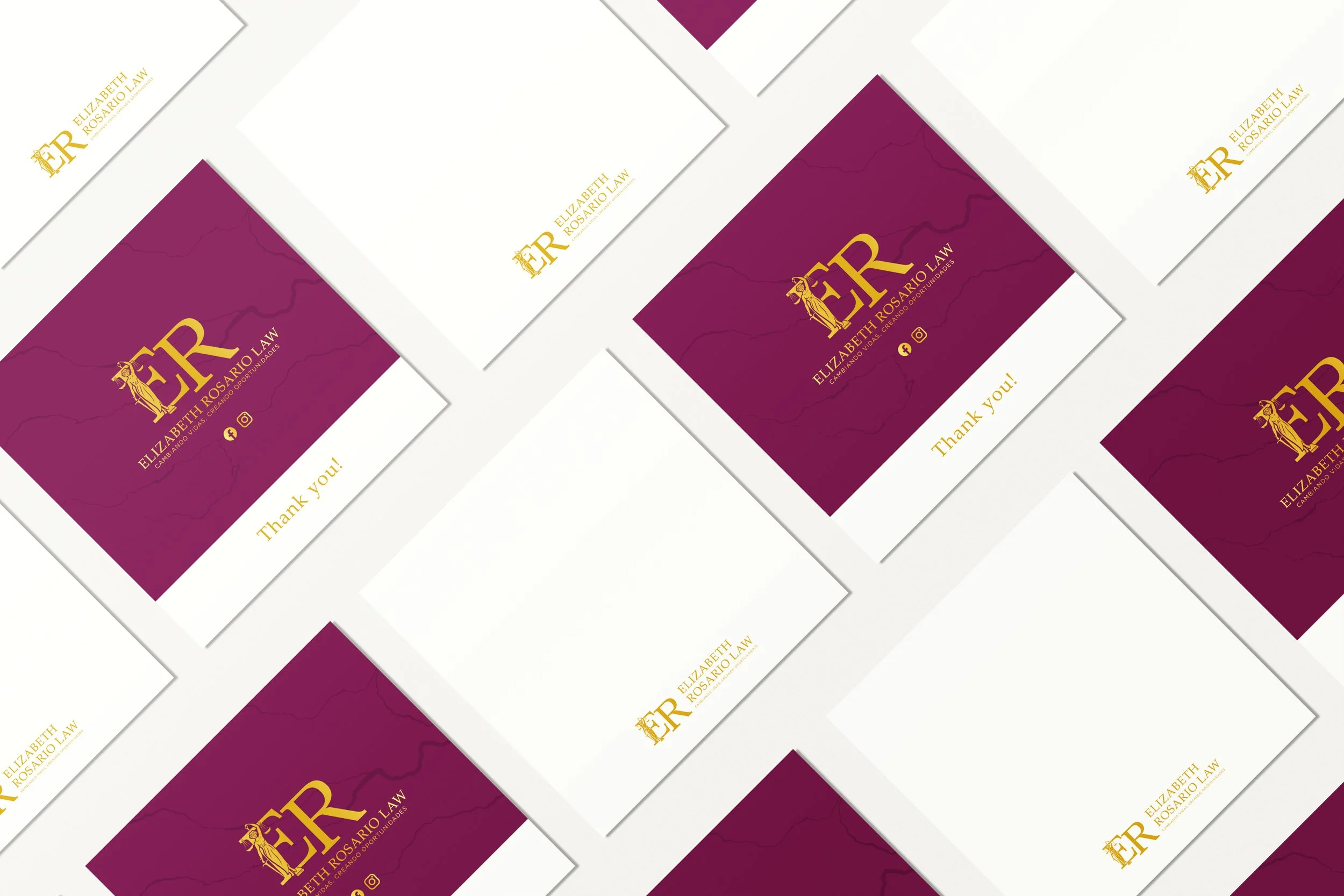 Business cards with a purple background, featuring a gold logo and text for Elizabeth Rosario Law, and white cards with similar gold text. Some cards are arranged in a scattered pattern on a white surface.