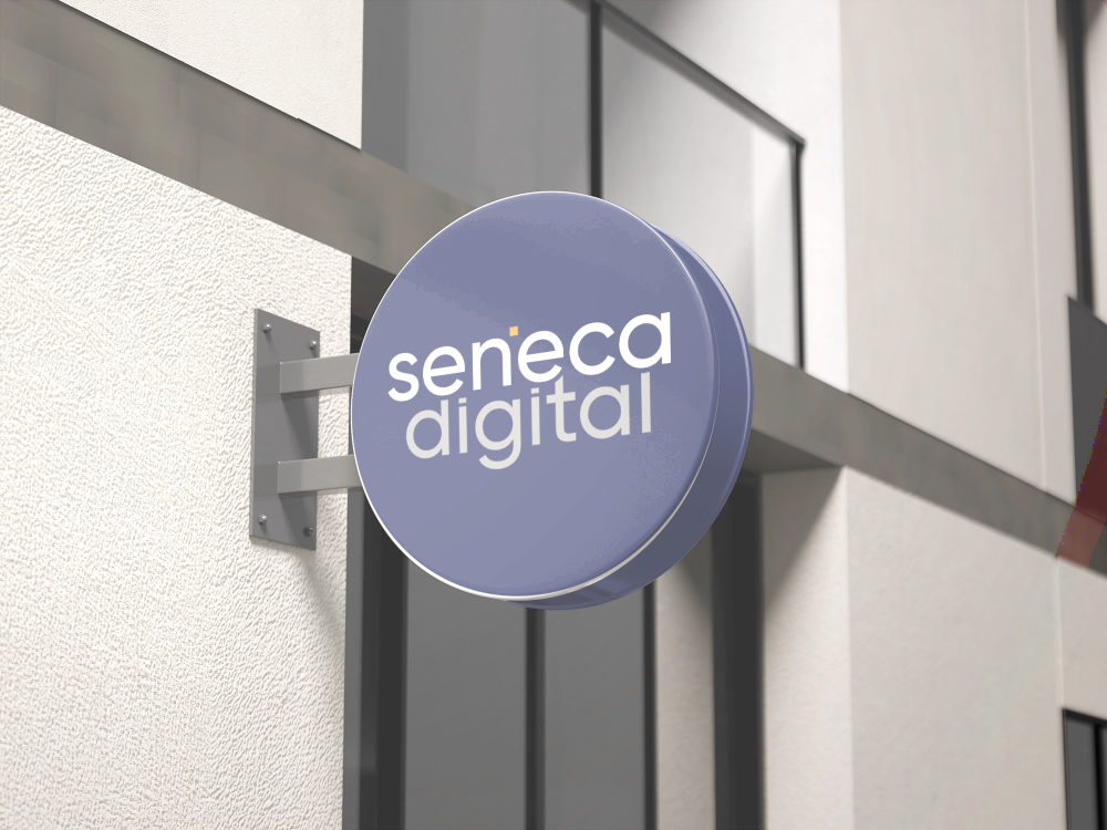 A circular sign for Seneca Digital mounted on the exterior wall of a building.
