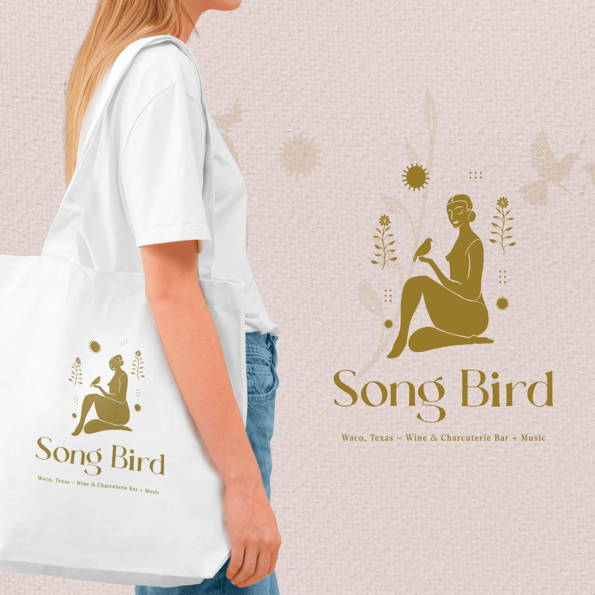 A white tote bag with a logo of a woman sitting with a bird on her hand, surrounded by floral and bird illustrations, and the text "Song Bird" and "Waco, Texas - Wine & Charcuterie Bar + Music" on a light pink textured background.