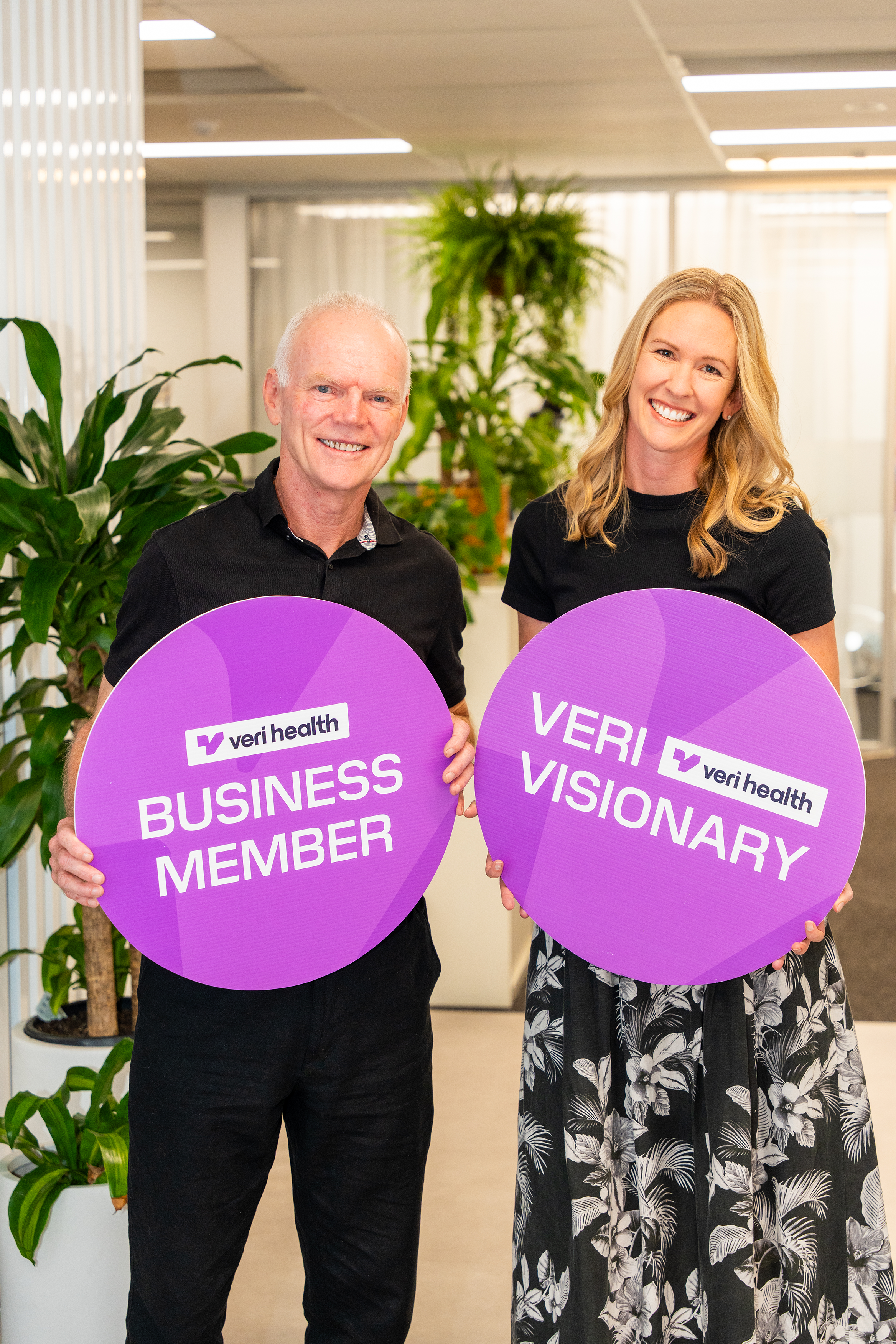 We Are HR team holding Veri Health Business Member and Veri Visionary signs