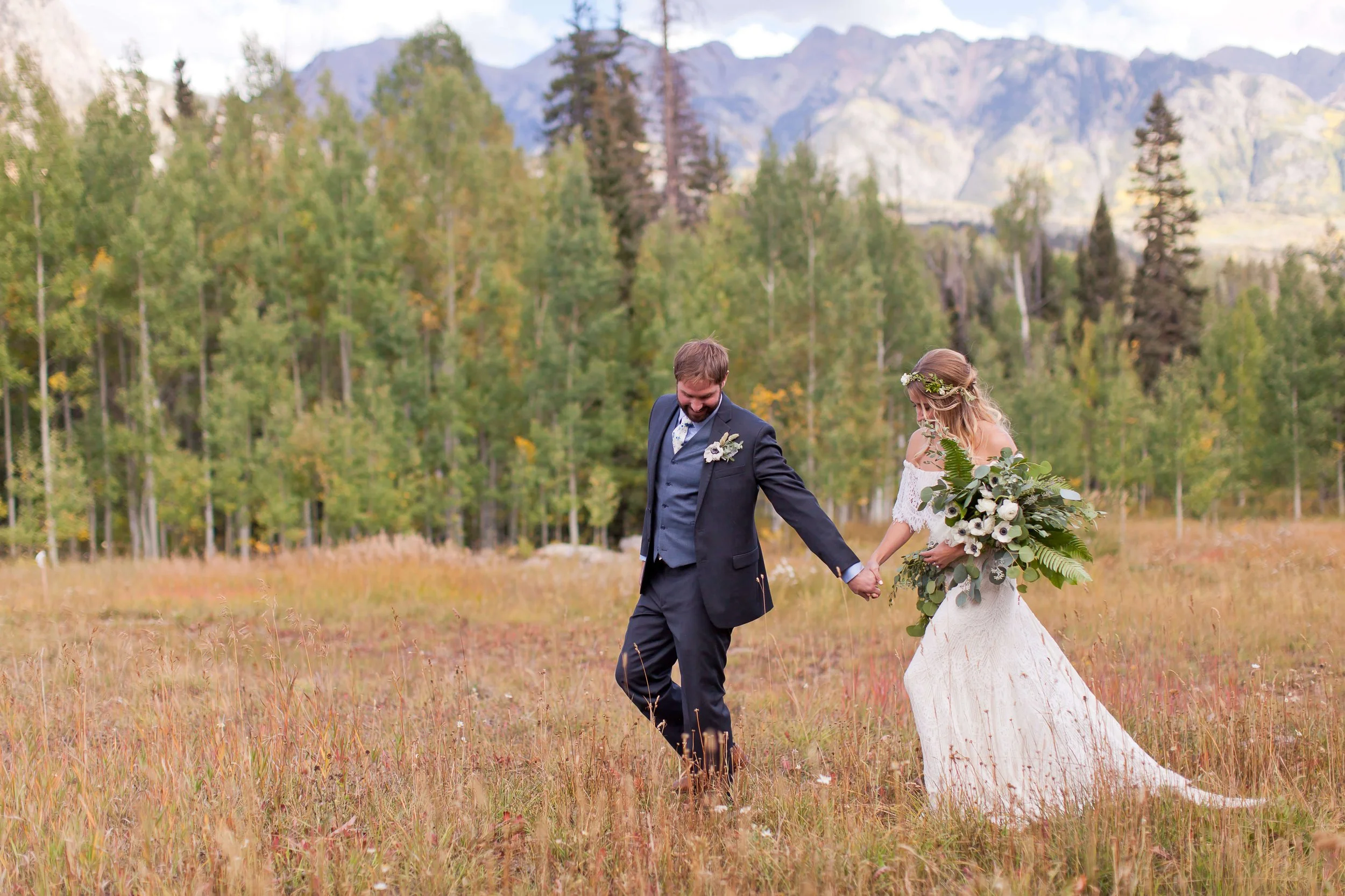 Bride and groom standing in front of golden fall aspens at The Benchmark at Cascade Village during a natural boho wedding.