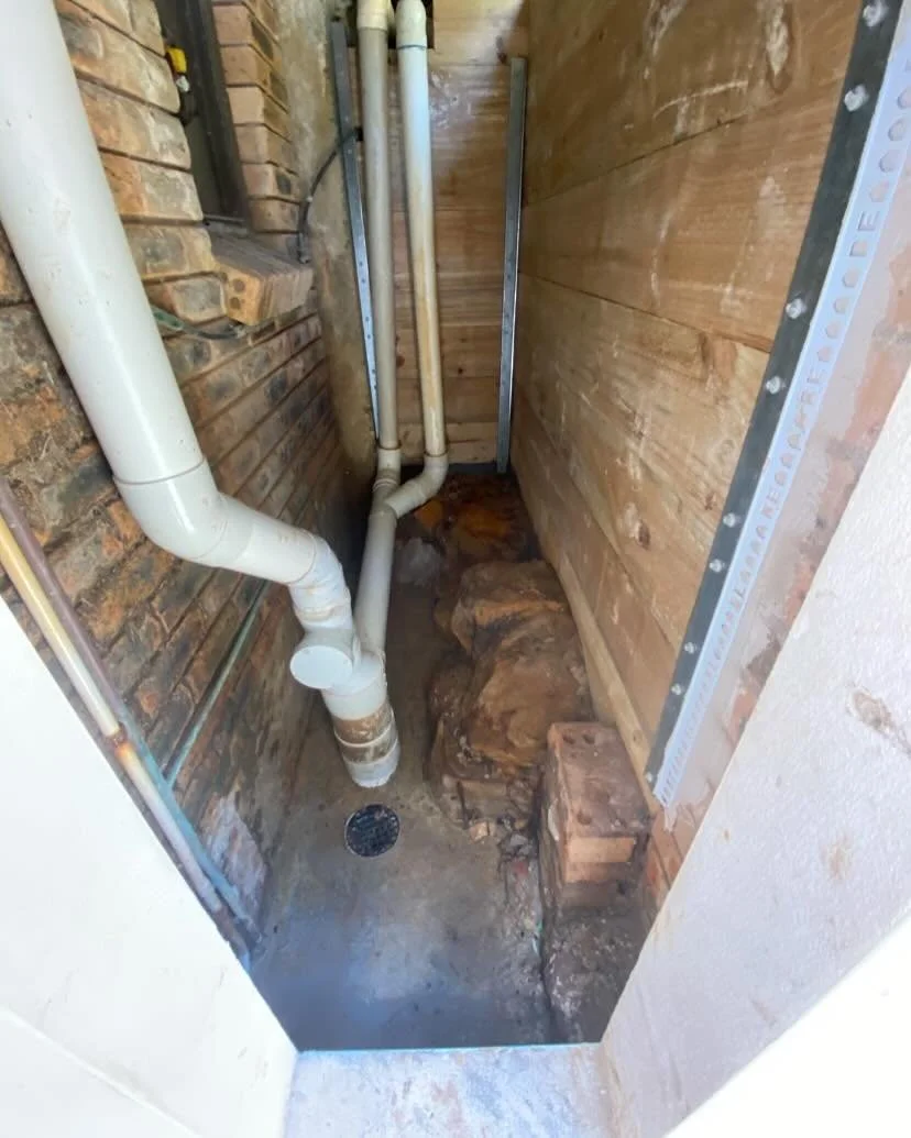 Retaining wall build to prevent rocks falling onto plumbing pipes.