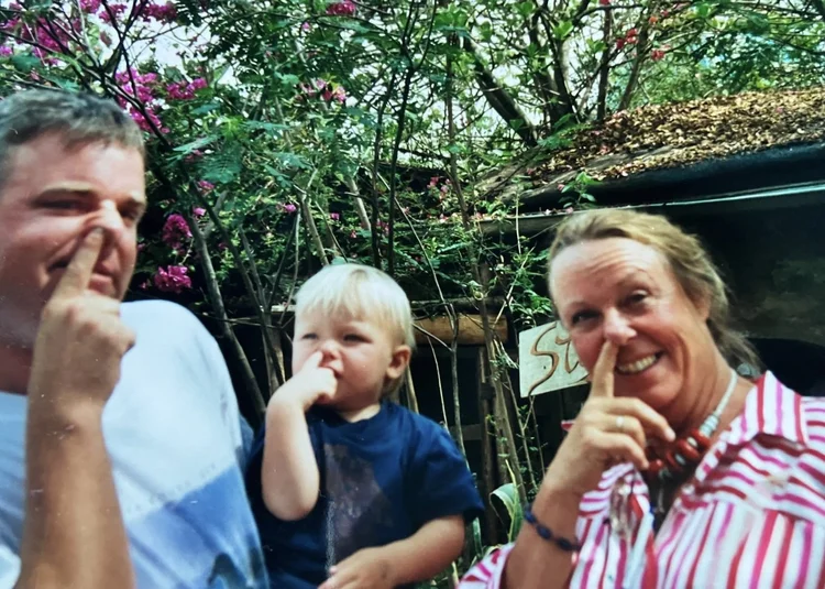 Family archive photograph of adults and a small child outdoors.