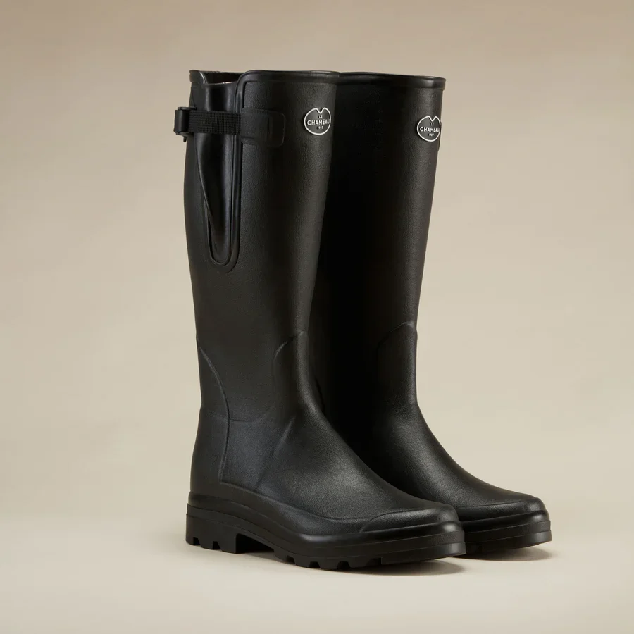 Pair of black rubber rain boots with a small adjustable strap at the top and a