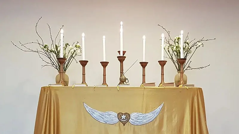 Altaar met kaarsen en het gevleugelde hartsymbool van Soefisme.