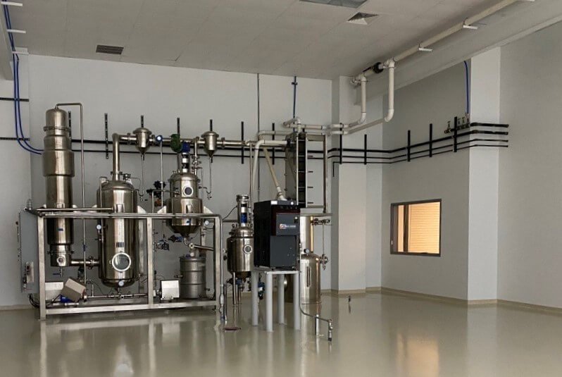 Stainless steel distillation and extraction system in cleanroom pharmaceutical processing facility with epoxy flooring
