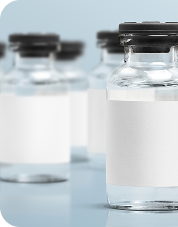 Pharmaceutical vials with white labels and black caps on light blue surface for medication storage