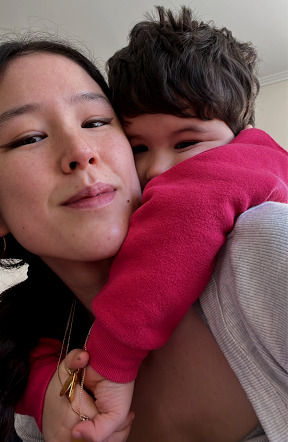 A woman and a young boy hugging closely, both smiling softly.