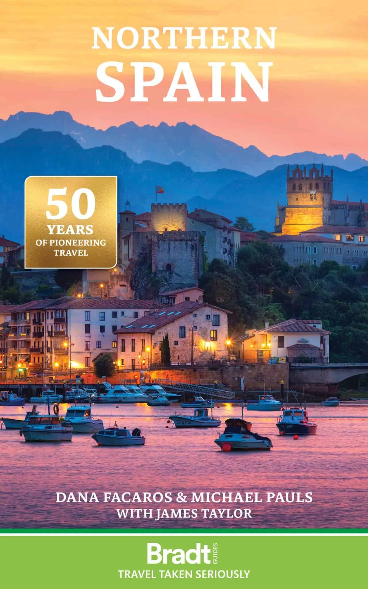 Cover of a travel guidebook titled 'Northern Spain' with a scenic view of a town at sunset, showing boats in a marina, old buildings, a castle, and mountains in the background. It highlights '50 Years of Pioneering Travel' and features authors Dana F