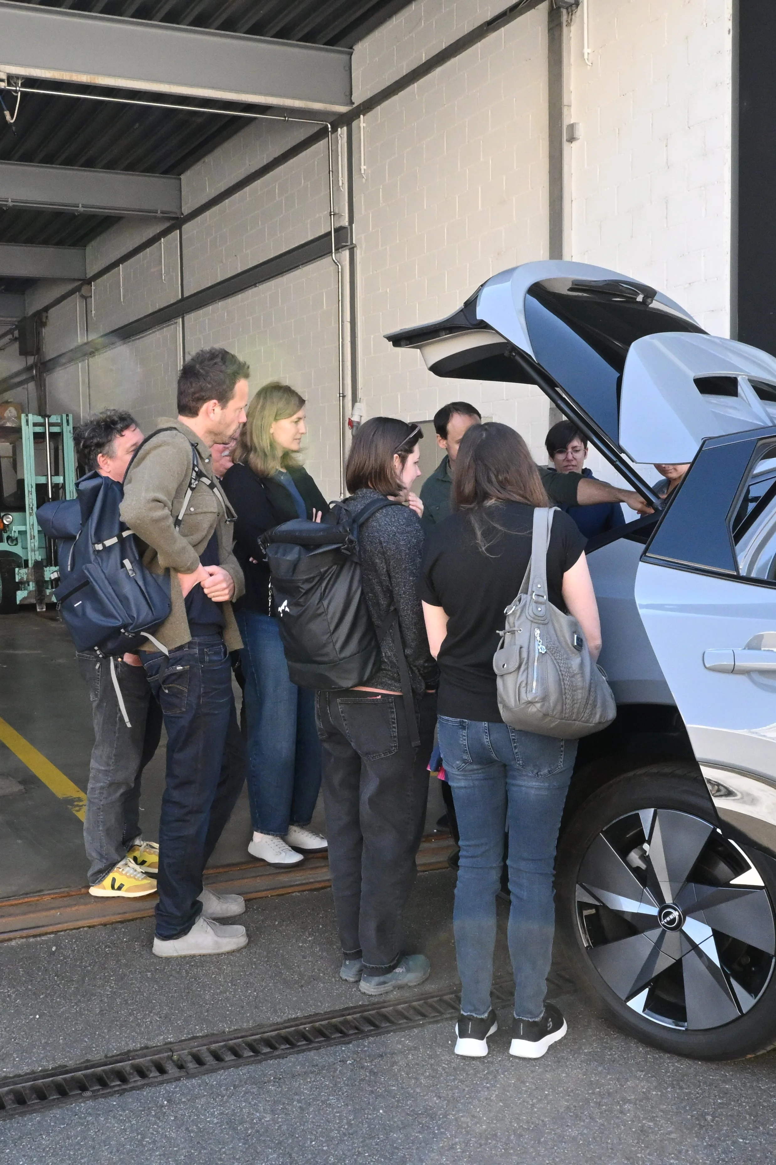 Exkursionsteilnehmer:innen inspizieren die Technik im Kofferraum