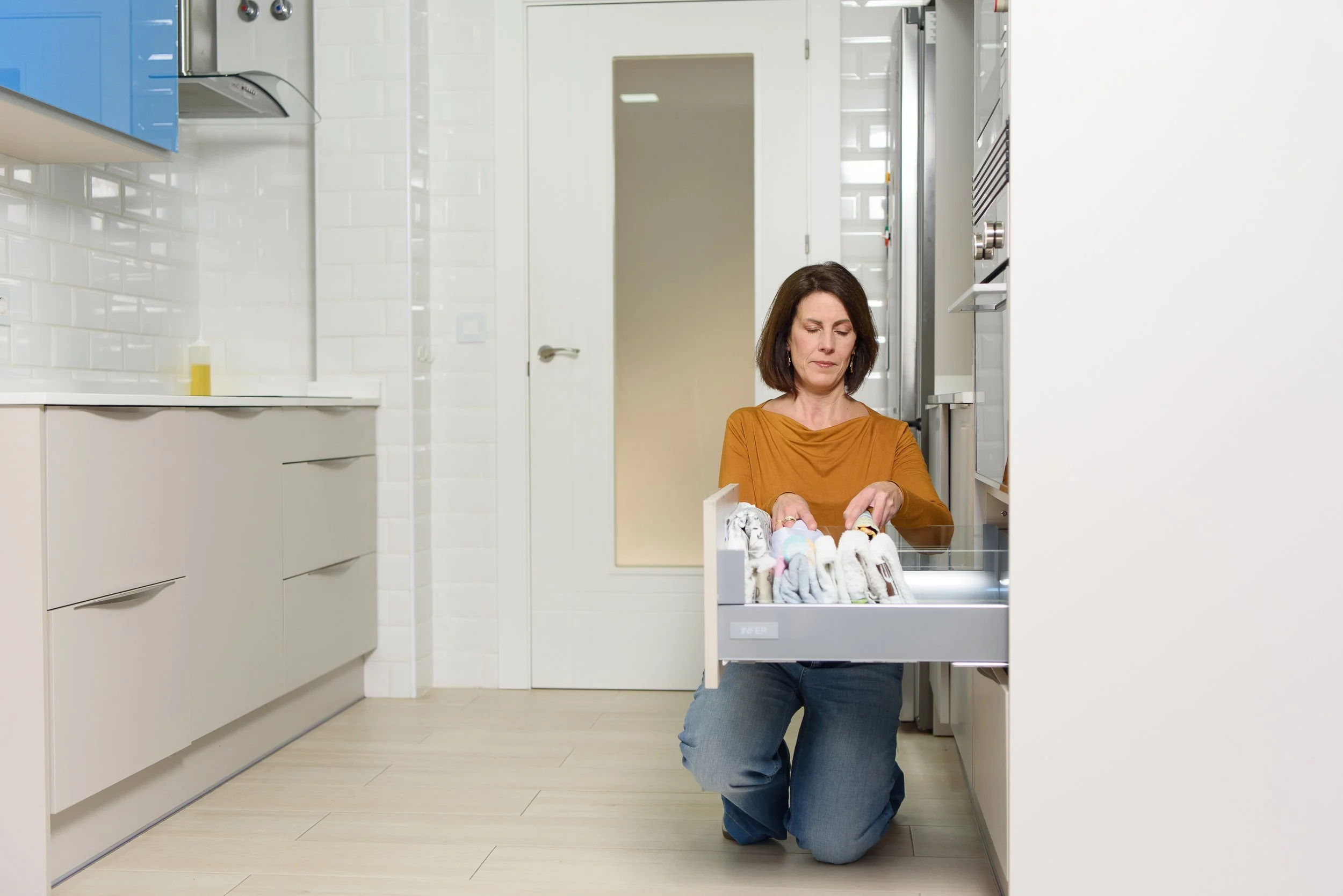 Mujer colocando ropa interior en un cajón de la cocina