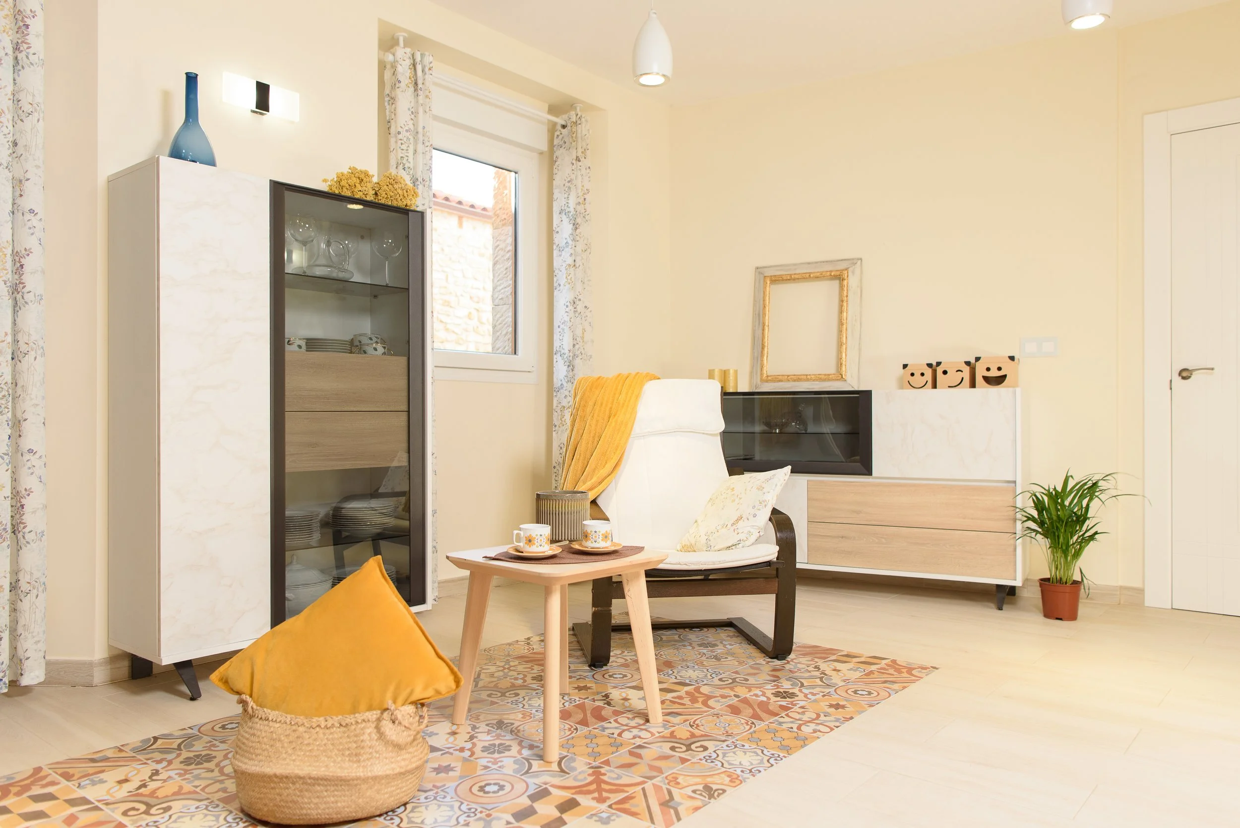 Vestidor y salita de estar en tonos claros con muebles de madera y plantas decorativas