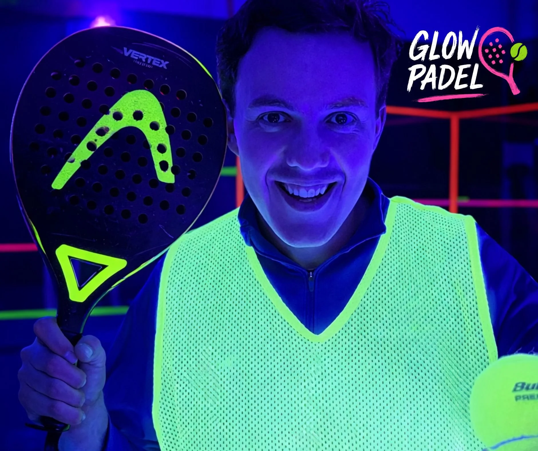 Person smiling, wearing a glow-in-the-dark yellow vest, holding a neon yellow padel racket with a matching design, in a dark environment with neon-colored lines and the words 'Glow Padel' in the top right corner.