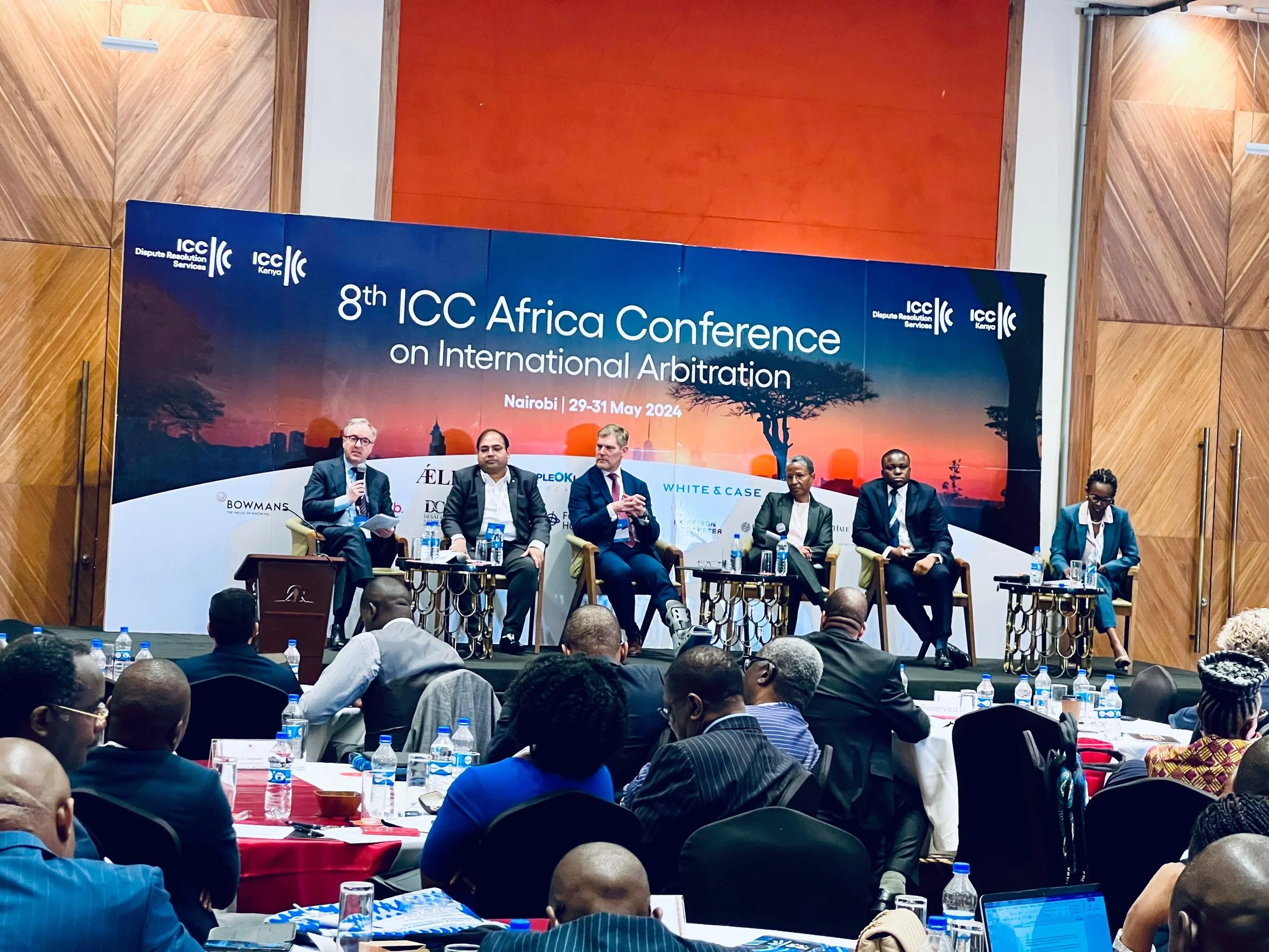 Panel discussion at the 8th ICC Africa Conference on International Arbitration in Nairobi from May 29-31, 2024, with six panelists seated on stage and an audience in front.