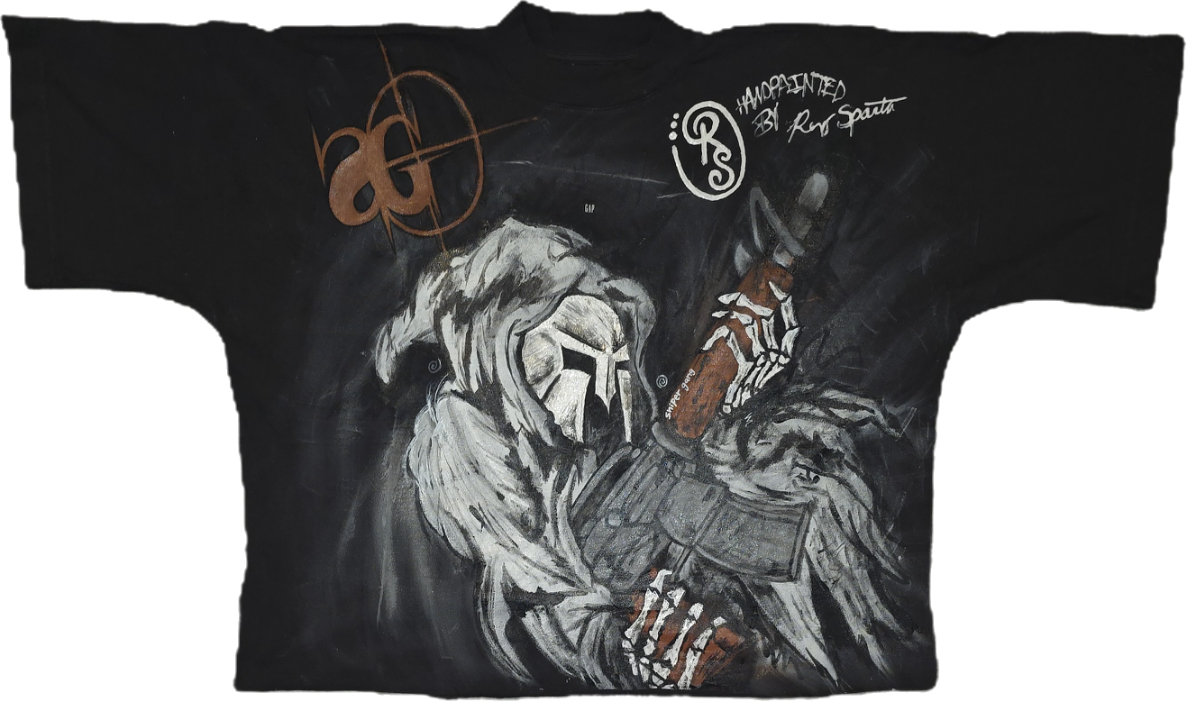 A black T-shirt with a painted illustration of a figure wearing a hood and a helmet with a star, holding a bobblehead doll in one hand and a book in the other. The shirt has signatures and signatures, including the words 'Handpainted by Ron Serta.'