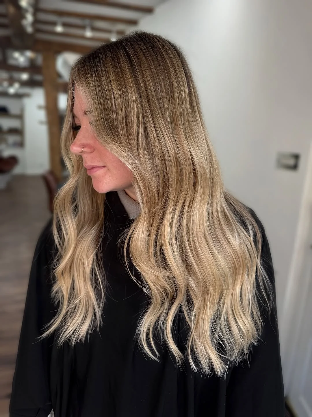 Woman with long, wavy blonde hair in a salon.