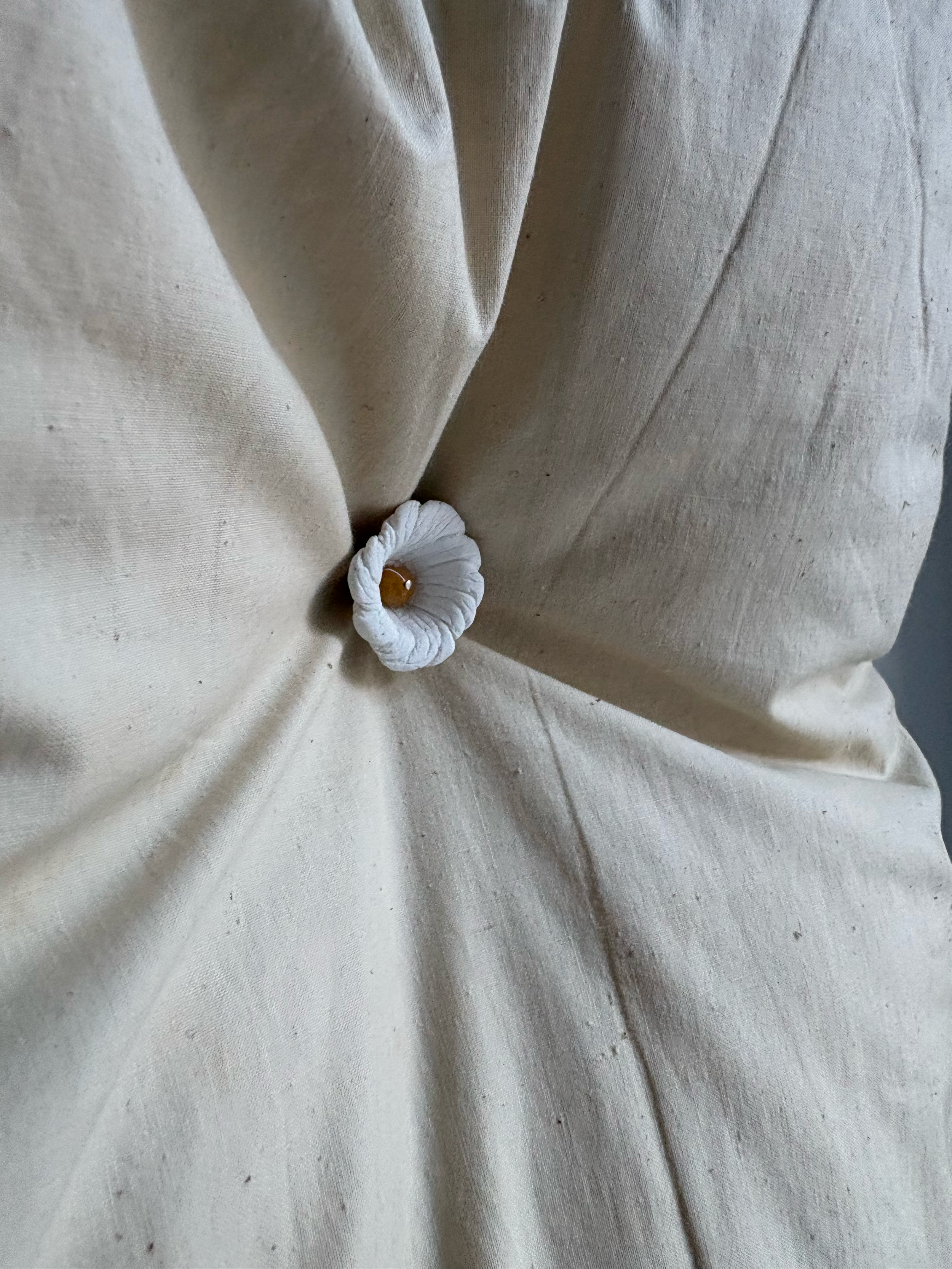 Picture of a pillow art piece with a flower shaped button