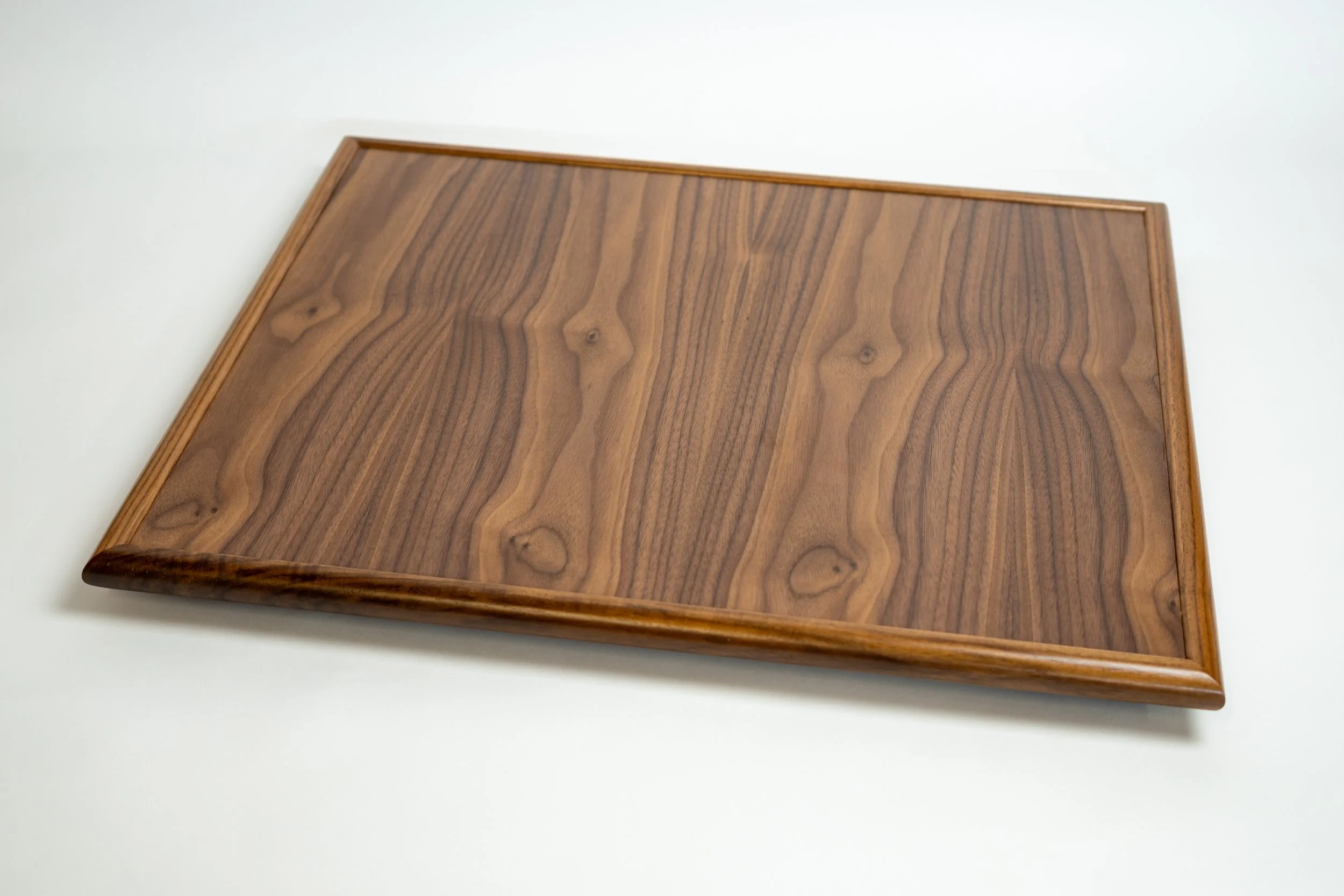 A wooden square table with a natural wood grain pattern and a slightly beveled edge, placed on a white surface.
