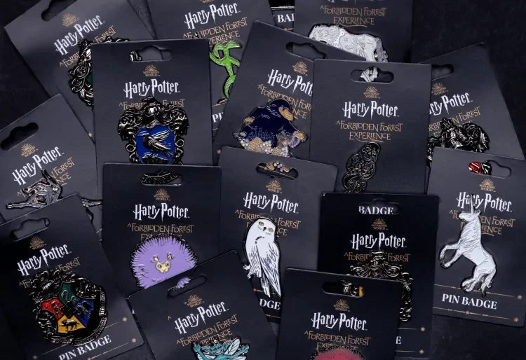 Collection of Harry Potter-themed enamel pins on black backing cards, featuring characters and symbols from Harry Potter and the Forbidden Forest Experience.
