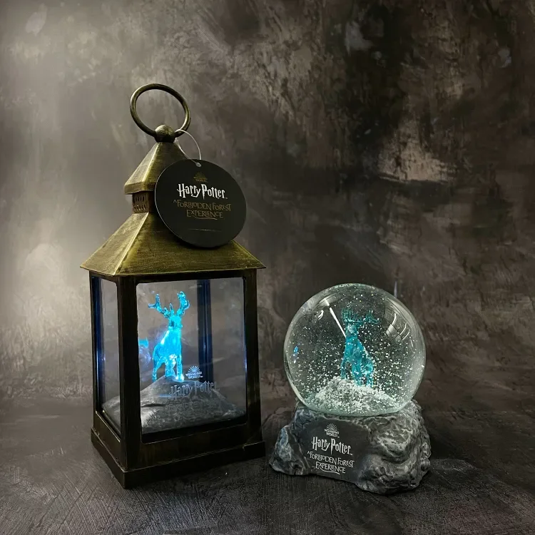 Harry Potter themed lantern and snow globe featuring a illuminated blue stag, labeled 'Harry Potter Forbidden Forest Experience'.