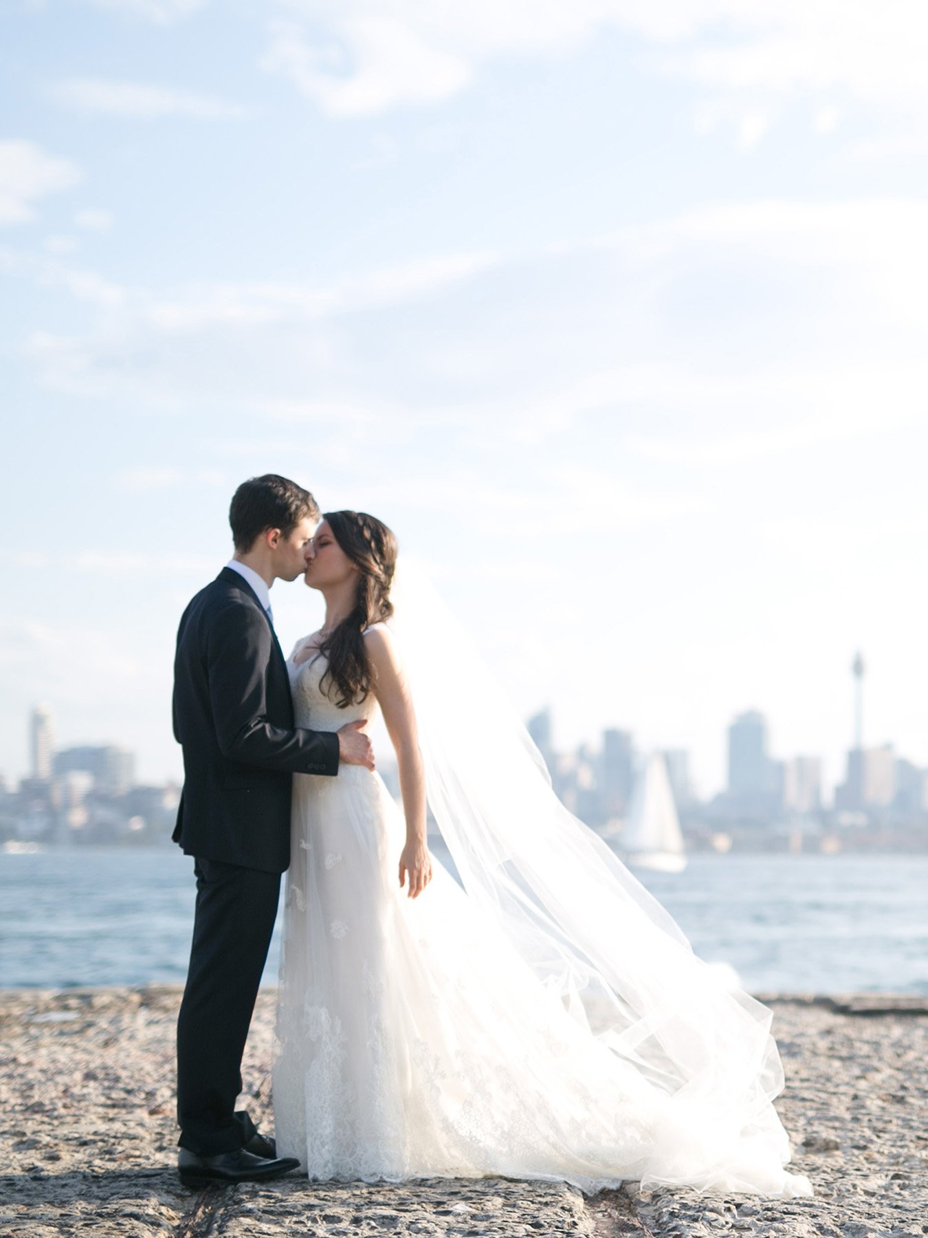 bridal couple kiss on stone pier bradleys head mosman