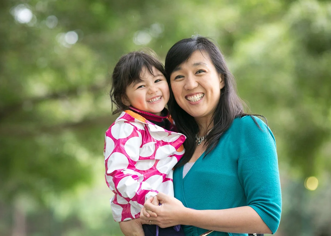 Mother holding young daughter in park