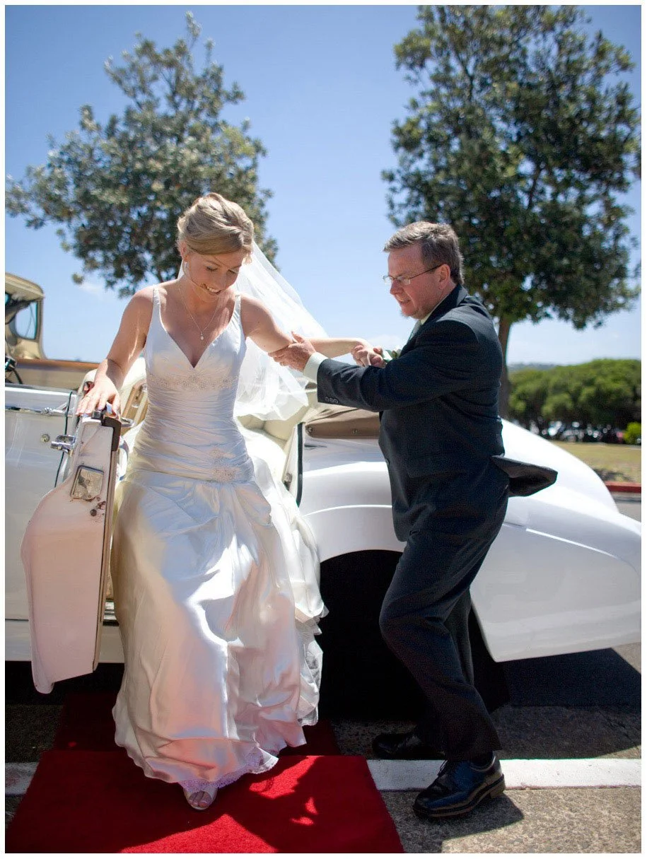 Father helping bride from car at HMAS Watson Chapel, Watsons Bay