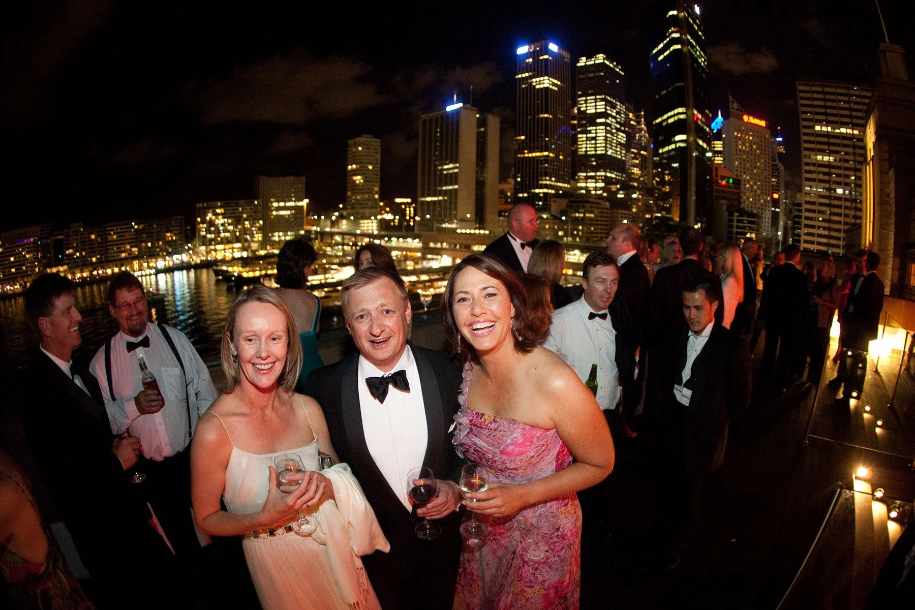 Wedding guests on the Museum of Contemporary Art terrace at night with Circular Quay city lights reflected on the harbour