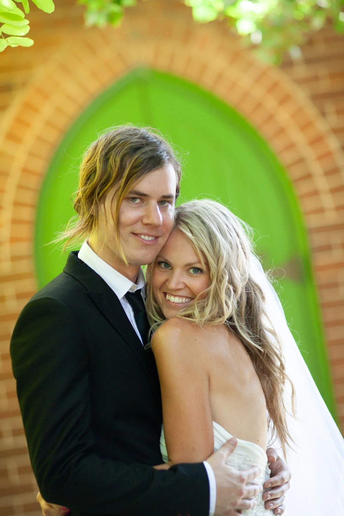 Groom embracing bride portrait arched door n at St Marks Darling Point