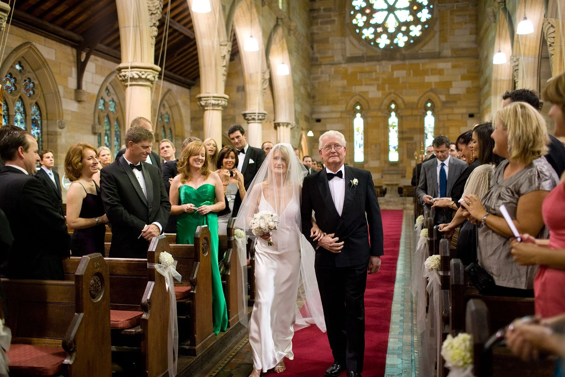 Bride walking down the aisle on her father's arm at All Saints Anglican Church Woollahra