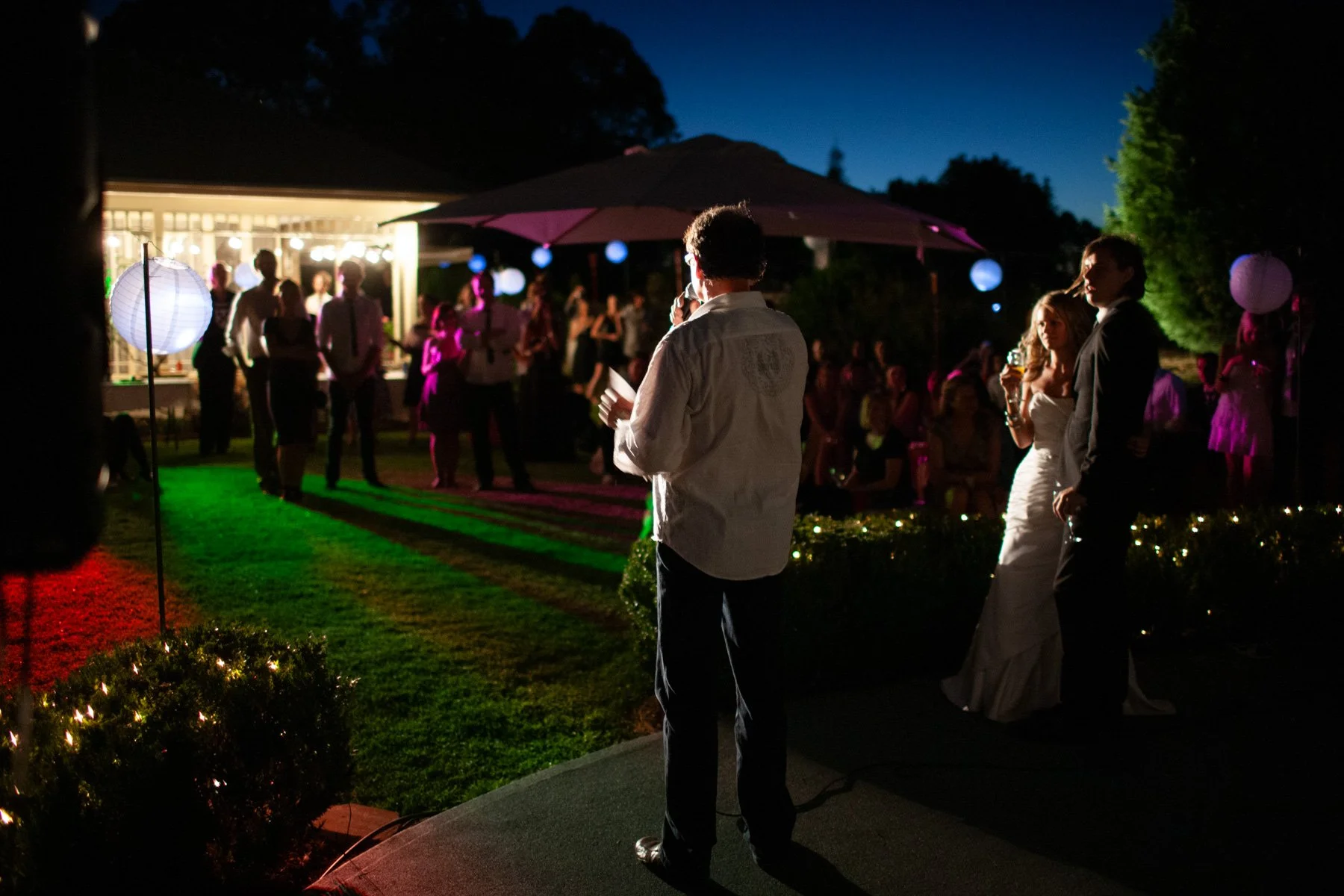 Father of bride reception speech at dusk outdoor private garden