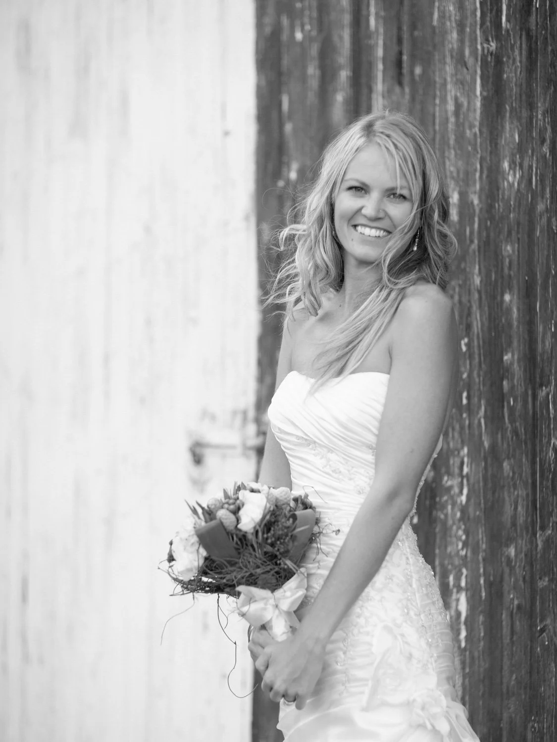 Bride portrait agains wooden warehouse doors