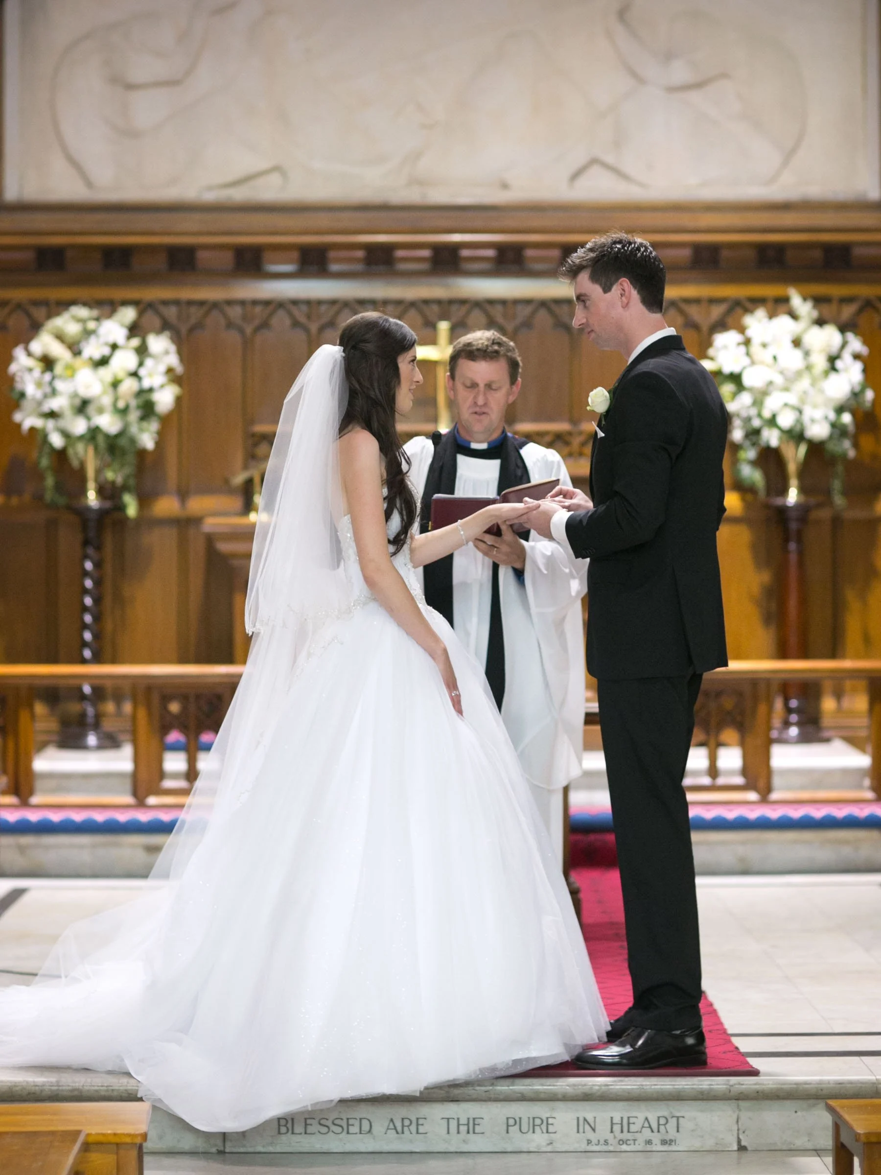 Couple at altar exchanging vows, Shore School Chapel, North Sydney