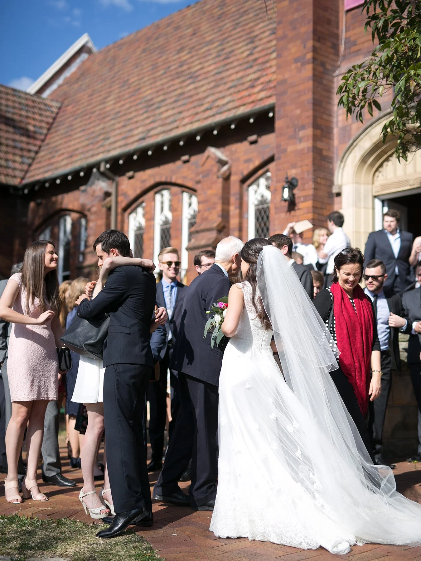Newlyweds receiving congratulations from guests outside St Andrews Anglican Church Roseville