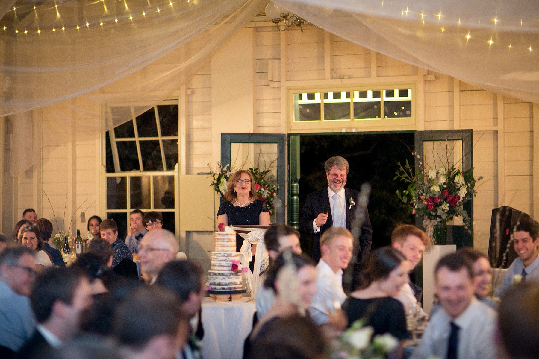 Wedding reception room set for dinner with fairy lights overhead, Athol Hall Mosman