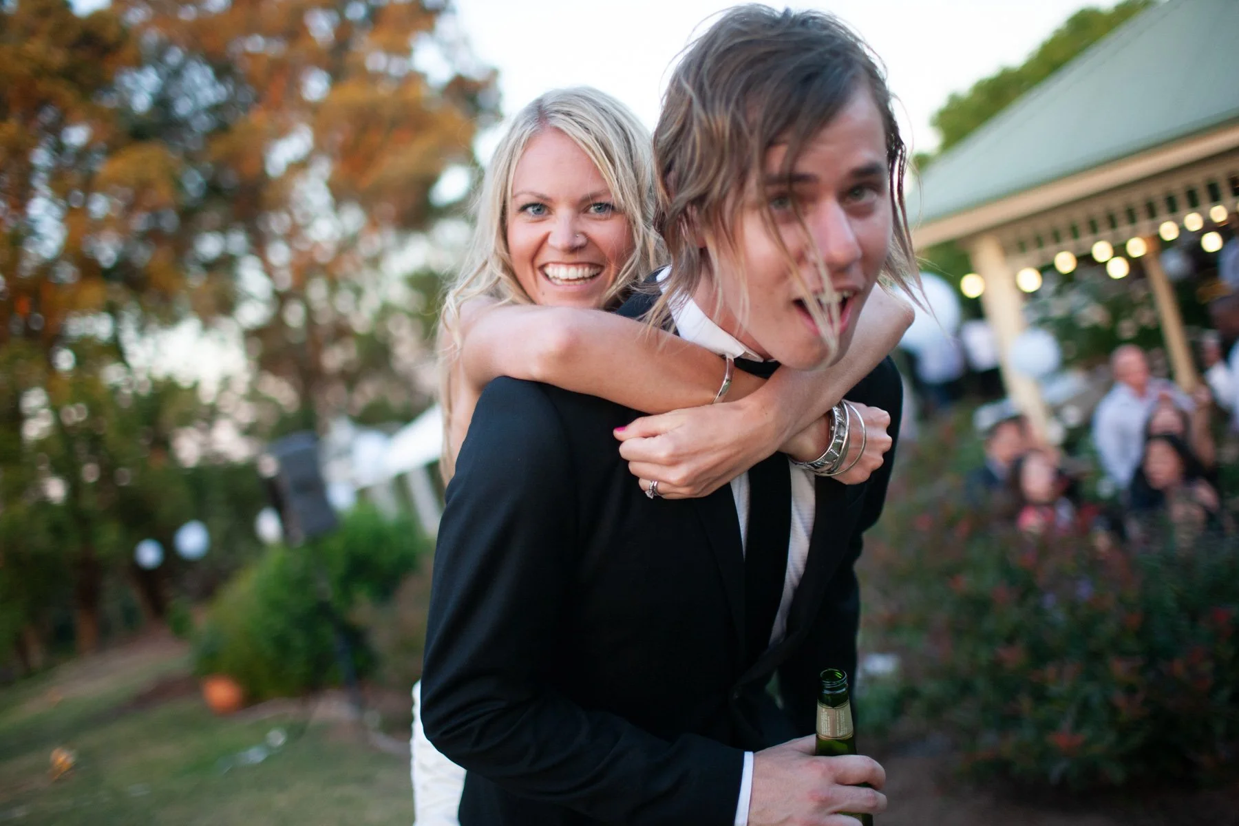 Couple candid piggyback moment at private garden reception