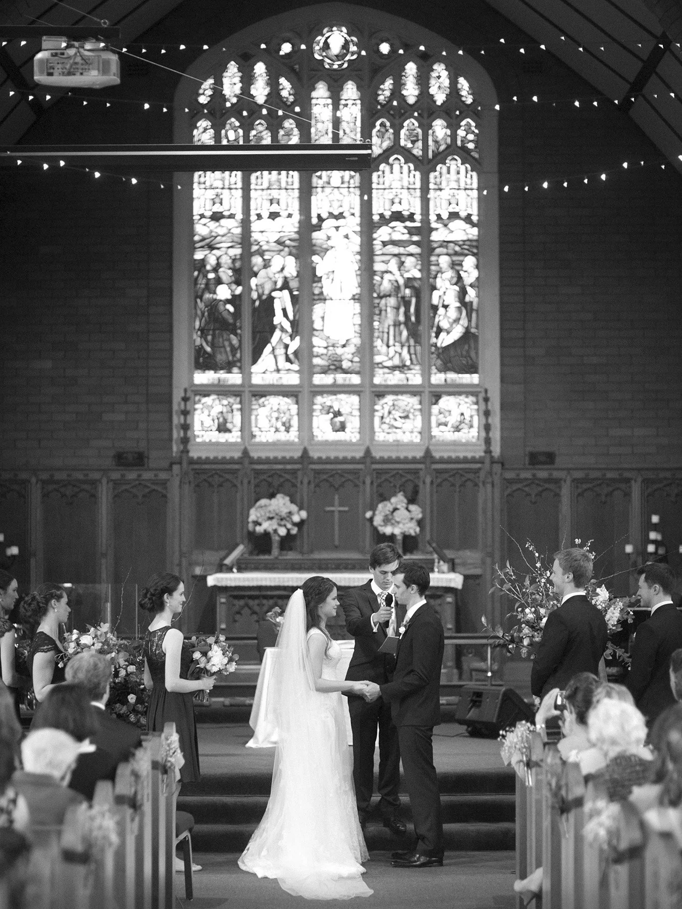 Couple exchanging vows beneath the stained glass windows, St Andrews Anglican Church Roseville