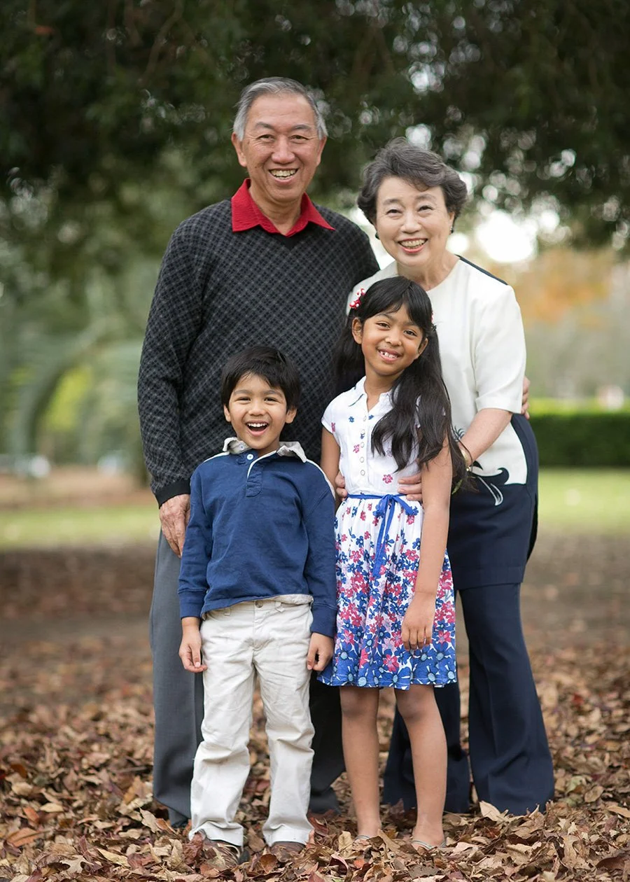 Grandparents with two grandchildren in autumn leaves