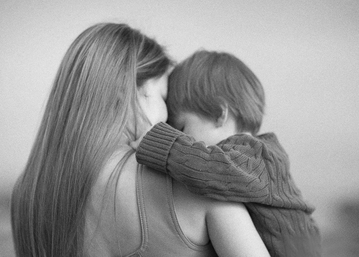 Mother and young son close up embrace