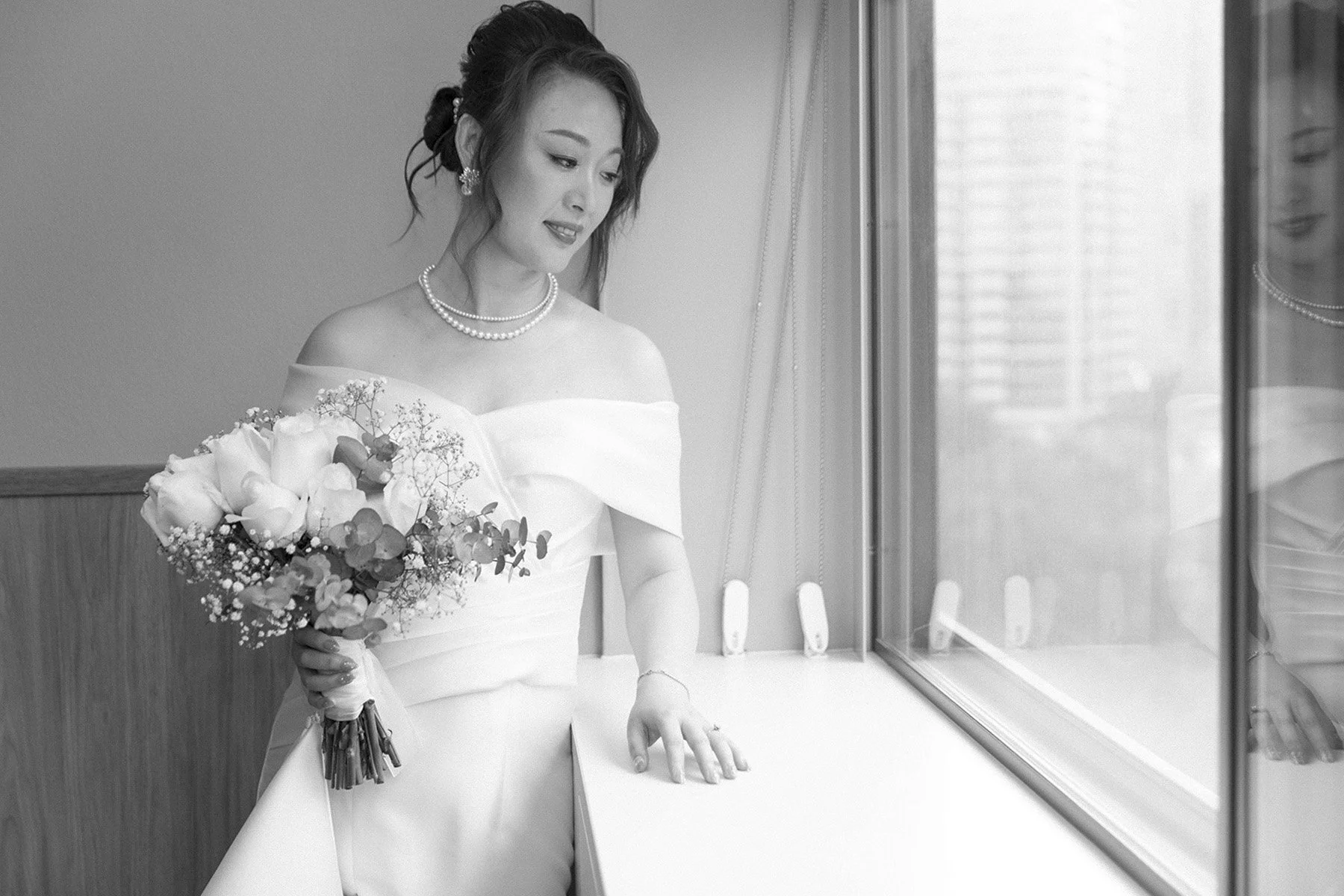 Bride with her bouquet at the window before the ceremony, Sydney