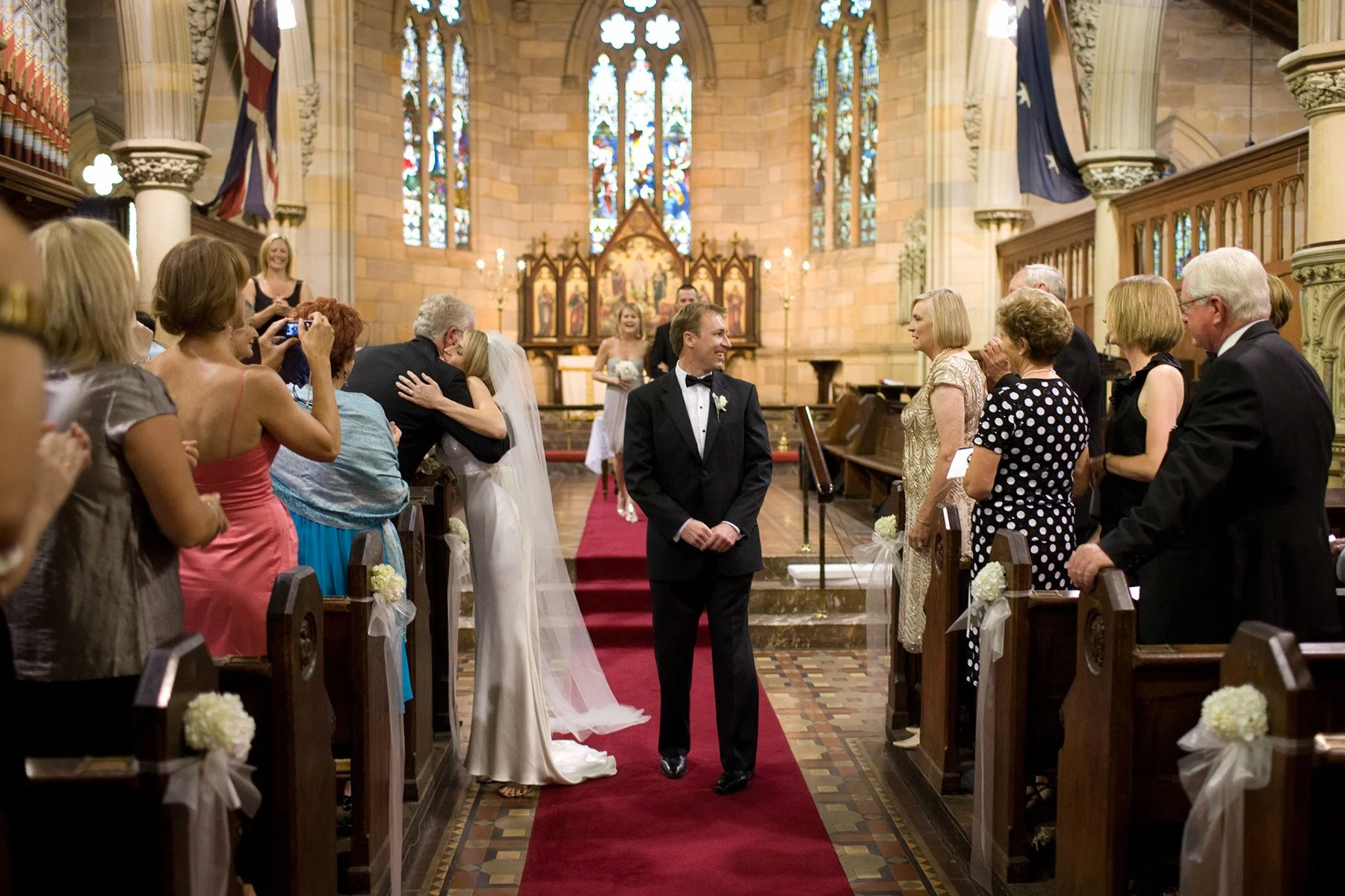 Guests embracing in the aisle after the ceremony at All Saints Anglican Church Woollahra
