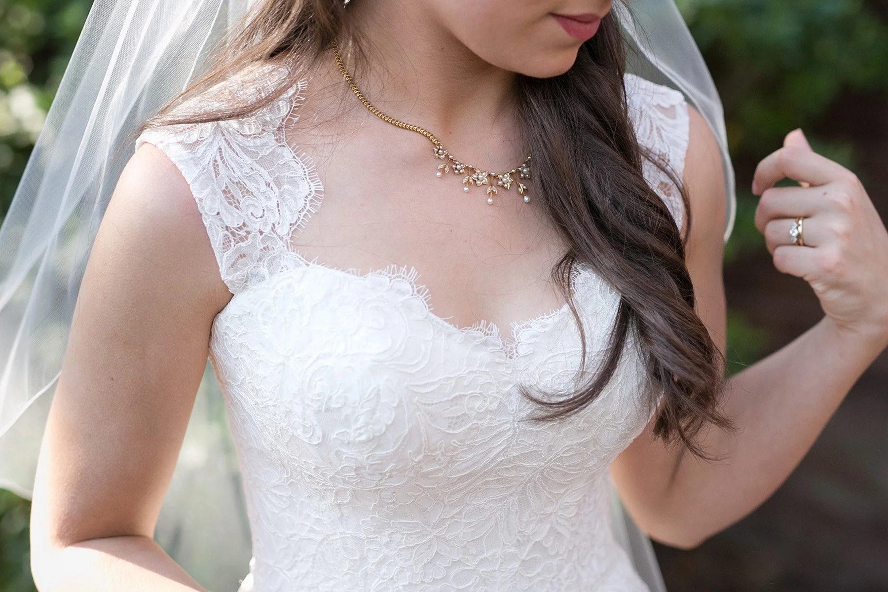 Close detail of bride's lace dress, veil and bouquet at Bradleys Head Mosman
