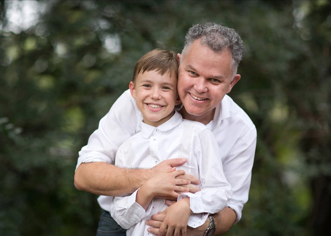 father embracing son lovingly in the back garden