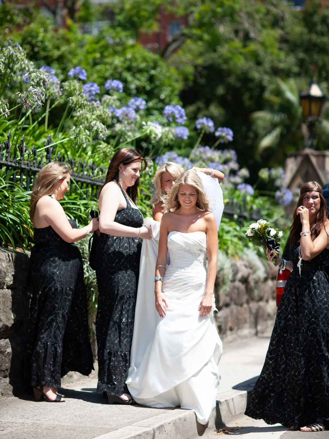 Bridesmaids making final adjustments to bride at St Marks Darling Point