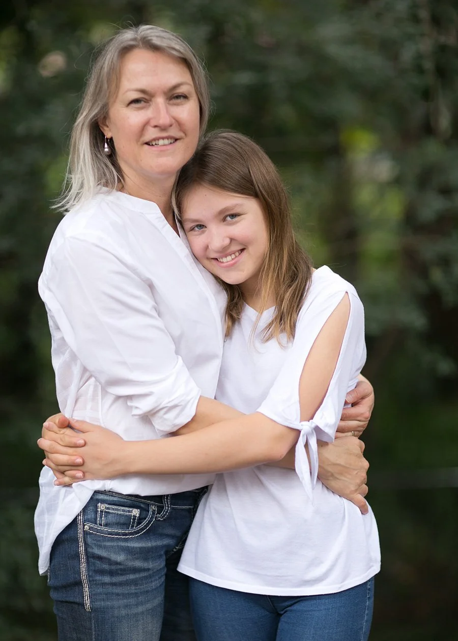 Mother and teenage daughter embracing in backyard
