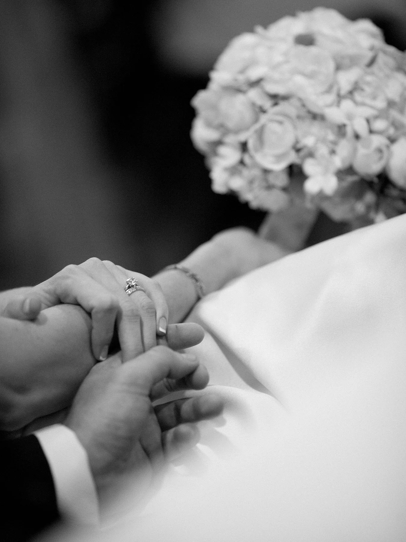 Black and white close-up of hands during the ring exchange at All Saints Anglican Church Woollahra