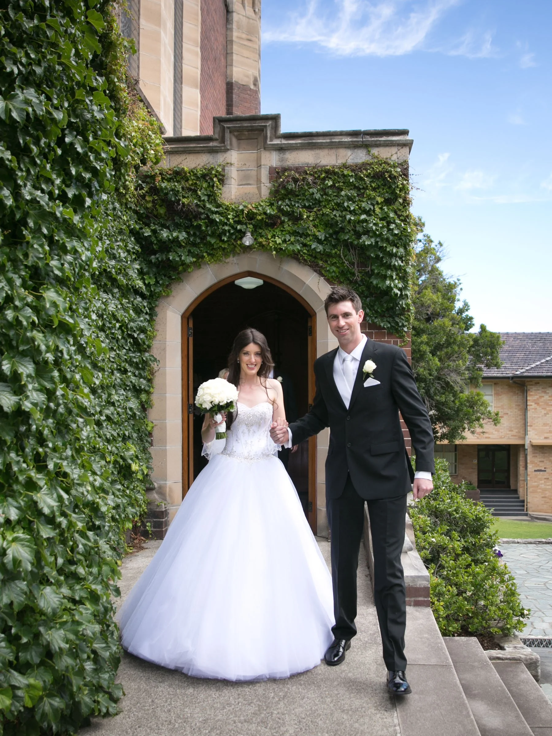 Newlyweds exiting through Shore School Chapel arch, North Sydney