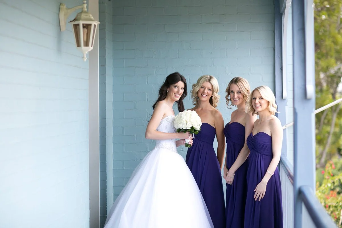 Bride with bridesmaids on balcony 